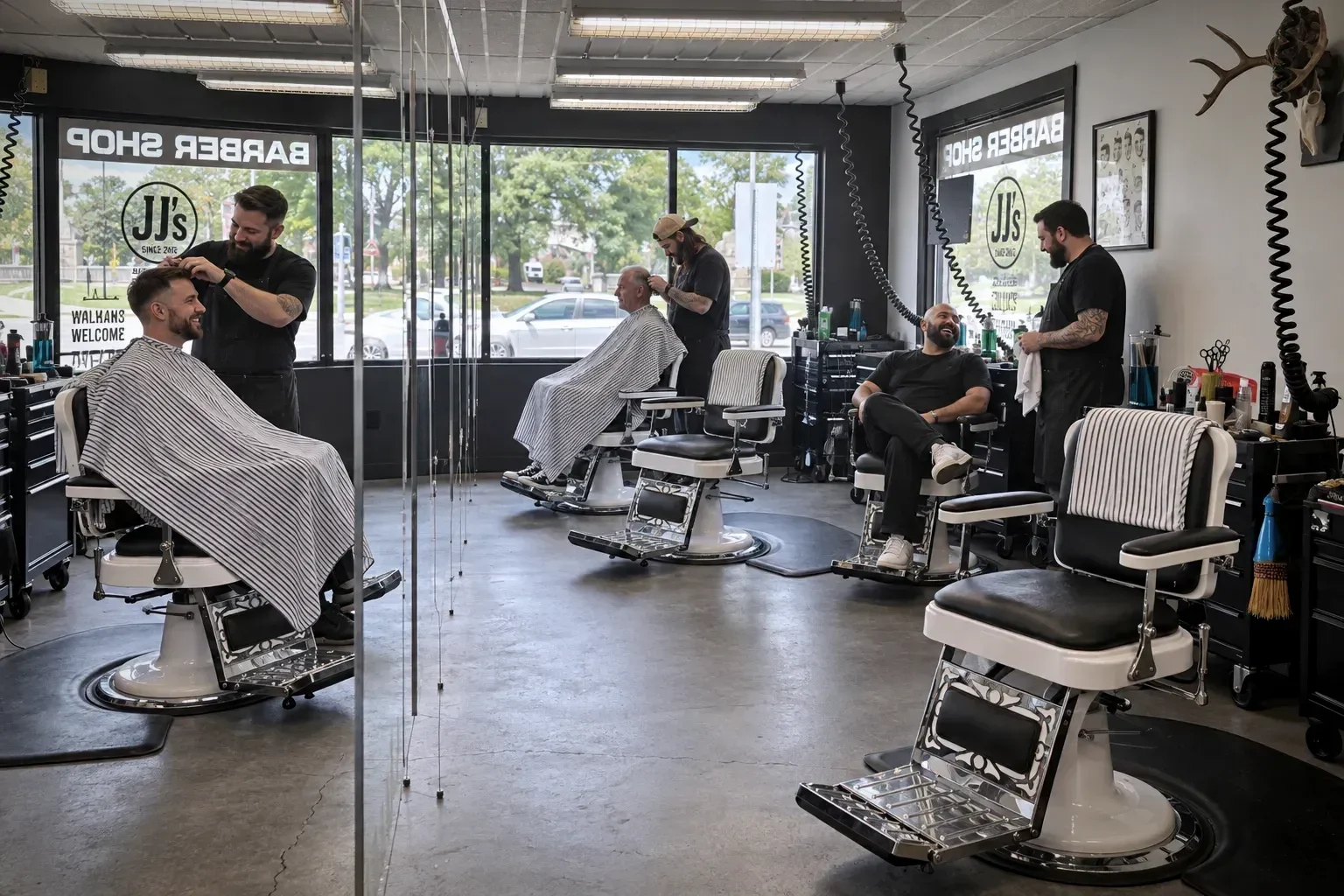 Barbers and clients across the shop floor at JJ's in Troy